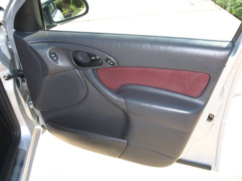 1993 Ford Bronco - The interior door panel of a car shows dark gray plastic and a maroon fabric insert.