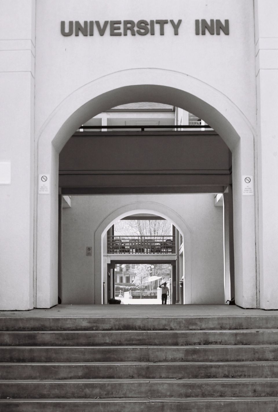 University Inn entrance with arches, stairs, and a person standing in the distance
