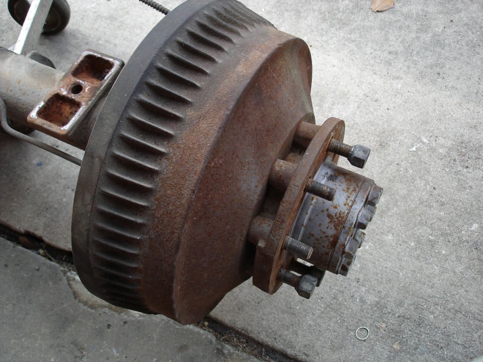 Rusty brake drum and hub assembly removed from an axle