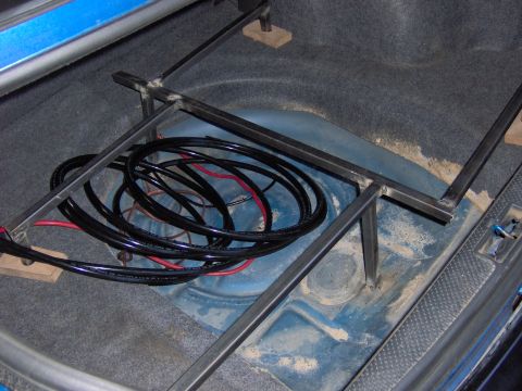 1996 Chevrolet Cavalier - Custom air ride suspension components, including coiled lines and a metal frame, are visible in the trunk of a vehicle.