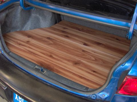 1996 Chevrolet Cavalier - Custom wood panel installed in the trunk of a blue car.
