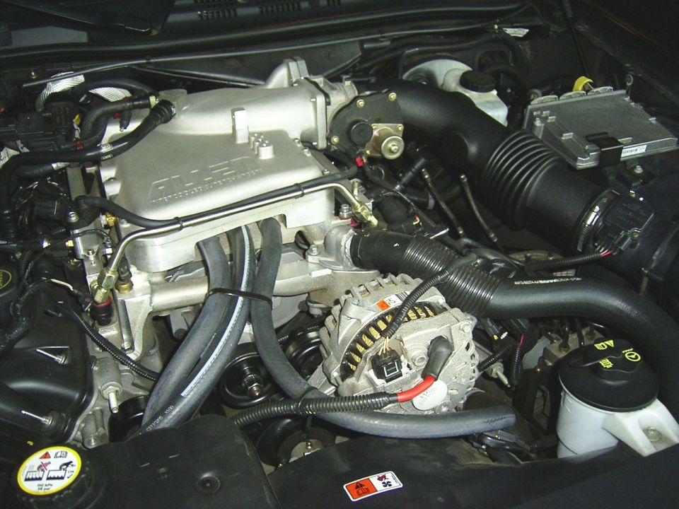 Engine bay of a Crown Victoria with Allen-branded aluminum intake/supercharger and alternator visible