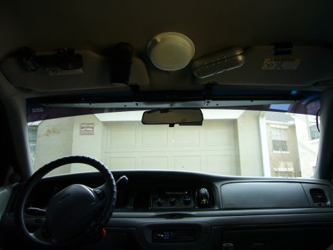2000 Ford Crown Victoria - The interior of a car is visible, showing the dashboard, steering wheel, and sun visors.