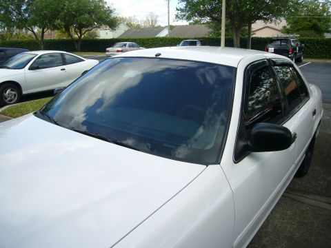 2000 Ford Crown Victoria - A white sedan is parked in a lot with other vehicles visible in the background.