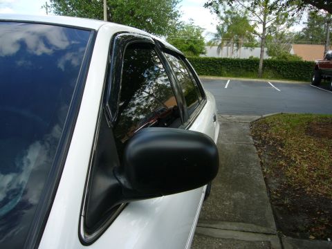 2000 Ford Crown Victoria - Side view of a white 2000 Ford Crown Victoria sedan parked next to a sidewalk.