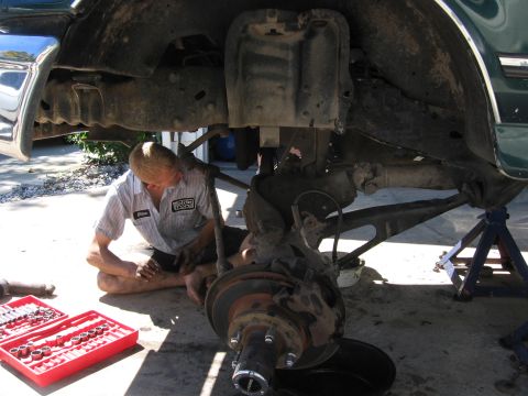 1974 Ford F-100 - Mechanic performs maintenance on a truck's front suspension system.