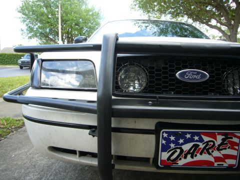 2000 Ford Crown Victoria - A white Ford Crown Victoria is equipped with a black push bumper and a D.A.R.E. license plate.