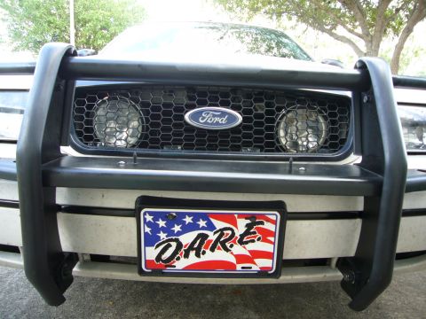 2000 Ford Crown Victoria - The front of a 2000 Ford Crown Victoria is visible, equipped with a bull bar and a D.A.R.E. license plate.