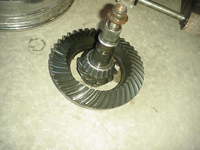 Ring and pinion gear set standing on a concrete floor, pinion shaft pointing up