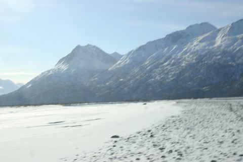 2003 Jeep TJ - A vast, snow-covered plain stretches towards snow-capped mountains under a bright, clear sky.