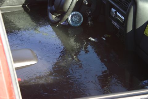 2003 Jeep TJ - Vehicle interior submerged in icy water, showing the steering wheel and dashboard.