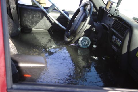 2003 Jeep TJ - The interior of a vehicle is submerged in water, with the steering wheel and dashboard visible.