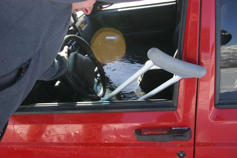 2003 Jeep TJ - A person's arm is visible reaching into the flooded interior of a red Jeep Cherokee.
