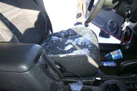 2003 Jeep TJ - Snow has accumulated inside the vehicle, covering the passenger seat and floor area.