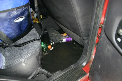 2003 Jeep TJ - Water has accumulated on the floor of the vehicle's interior, with various items scattered around.