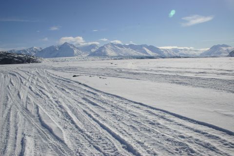 2003 Jeep TJ - Tracks mark a path across a snowy plain towards , snow-capped mountains.