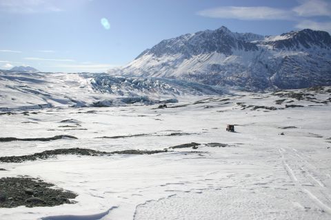 2003 Jeep TJ - Two vehicles traverse a vast, snow-covered terrain with a mountain range and glacier under a clear blue sky.