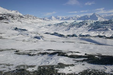 2003 Jeep TJ - A wide, expansive view of a glacier and surrounding snow-covered mountains under a bright blue sky.