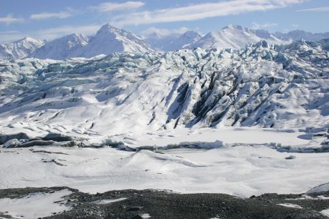 2003 Jeep TJ - A wide view of a massive glacier flowing between snow-capped mountains on a clear day.