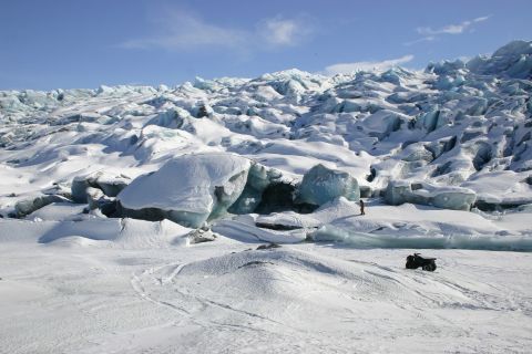 2003 Jeep TJ - An all-terrain vehicle navigates a vast, snow-covered glacier under a clear blue sky.