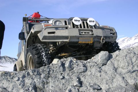 2003 Jeep TJ - A modified Jeep TJ navigates a rocky, off-road trail under a clear blue sky.