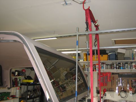 1996 Ford Bronco - A removable fiberglass hardtop hangs upside down from the garage ceiling, suspended by red ratchet straps and a threaded rod on a homemade…