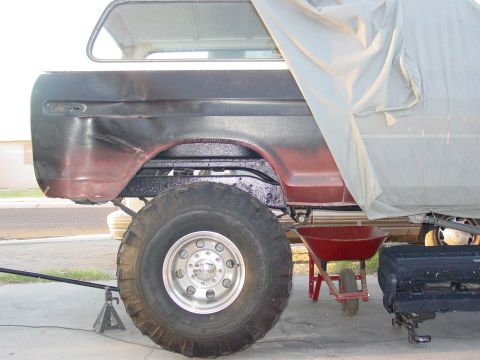 1979 Ford Bronco - This 1978 Ford Bronco is undergoing work, with a large tire and a tarp covering part of the body.