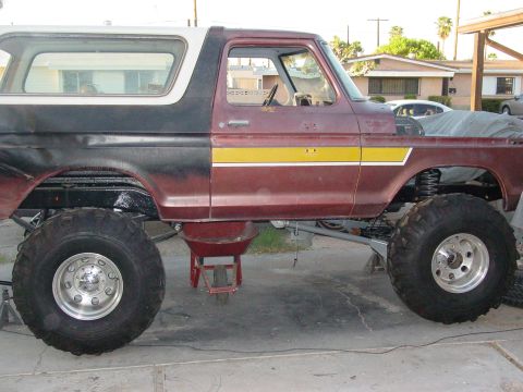 1979 Ford Bronco - This modified Ford Bronco is jacked up, showing off its massive tires and suspension components.