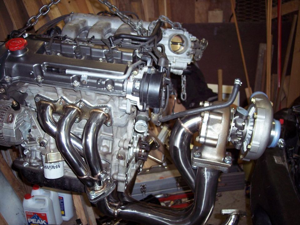 Engine block with turbocharger, custom exhaust manifold, and intake components. Oil filter visible