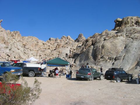 1985 Ford Bronco - A group of vehicles are gathered in a rocky desert area, with tents set up for an event.
