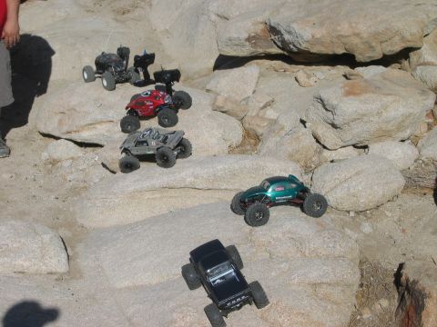 1985 Ford Bronco - Multiple remote control rock crawlers are shown navigating a challenging rocky obstacle course.