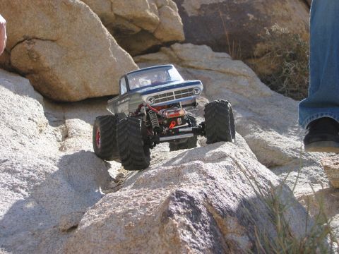 1985 Ford Bronco - RC rock crawler truck navigating a rocky desert terrain.