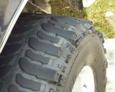 1989 Ford Bronco - Close-up view of a vehicle tire, showing its tread design and a portion of the wheel.