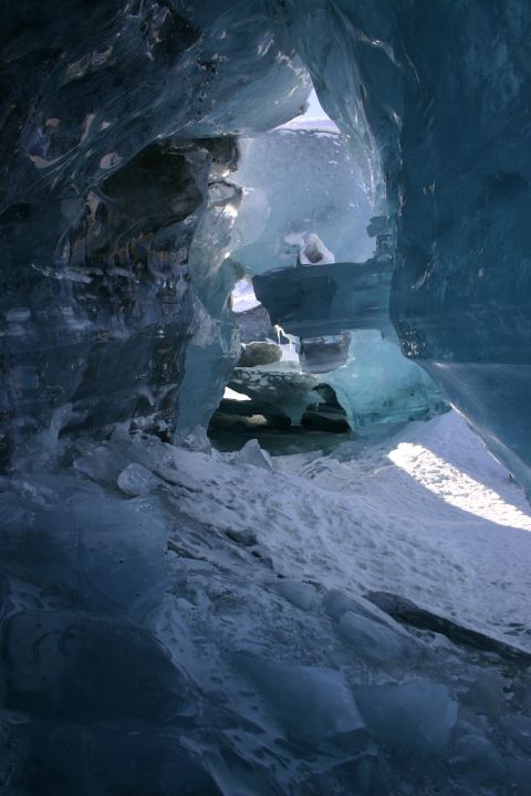 2003 Jeep TJ - Sunlight illuminates the interior of a vast ice cave, revealing intricate ice formations.