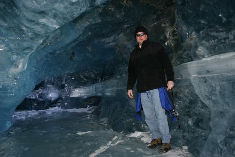 2003 Jeep TJ - A person stands inside a blue ice cave, with ice formations surrounding them.