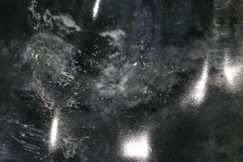 2003 Jeep TJ - Abstract patterns of water and light on a dark, wet surface.