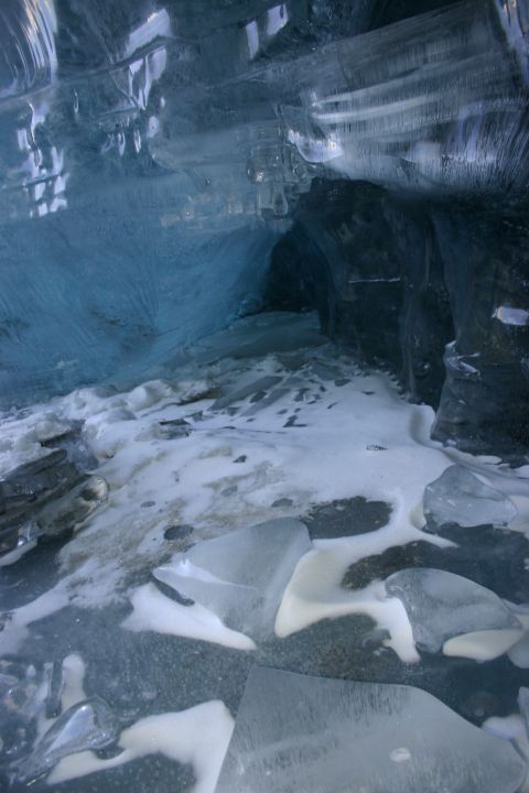2003 Jeep TJ - Inside an ice cave, showing the textured blue ice walls and a snowy, icy floor.