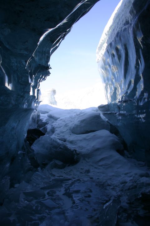 2003 Jeep TJ - View from inside an ice cave looking out towards a bright, snow-covered landscape under a clear blue sky.