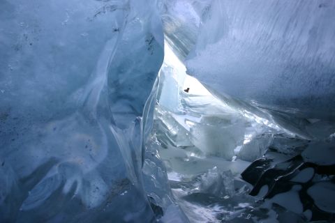 2003 Jeep TJ - A view from inside an ice cave, showing the intricate and fractured ice formations illuminated by light from an opening above.