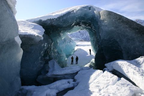 2003 Jeep TJ - People explore a glacial ice cave, with sunlight illuminating the blue ice.