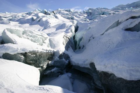 2003 Jeep TJ - Deep crevasses cut through the icy landscape of a glacier on a clear day.