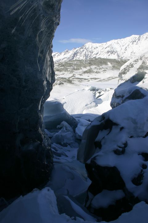2003 Jeep TJ - View from inside an ice cave looking out towards a snow-covered mountain range.
