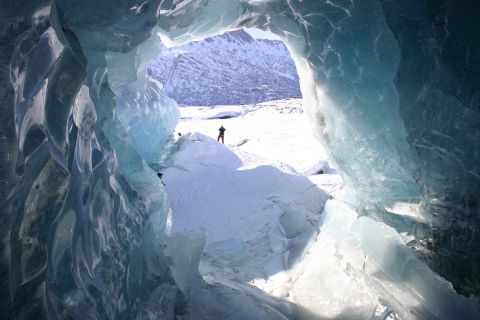 2003 Jeep TJ - Looking out from an ice cave at a snowy mountain landscape with a lone figure in the distance.