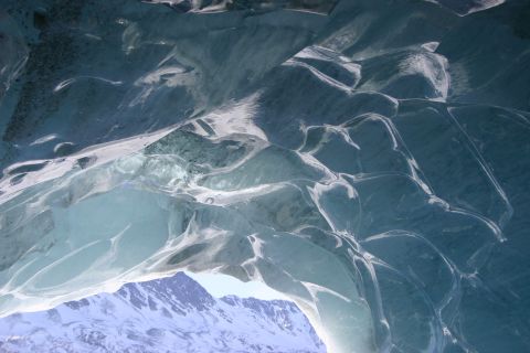2003 Jeep TJ - View from inside a glacial ice cave looking out at snow-capped mountains.