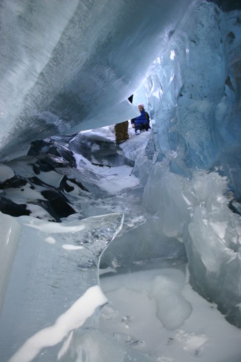 2003 Jeep TJ - Person exploring an ice cave, surrounded by formations of ice and snow.