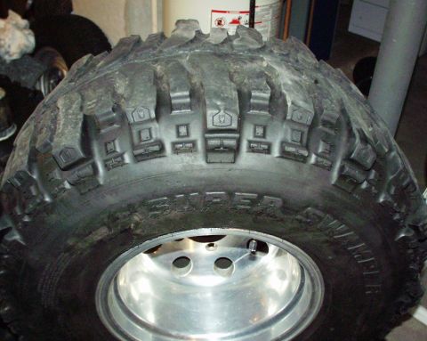 1989 Ford Bronco - Close-up of a Super Swamper tire mounted on a shiny chrome rim.