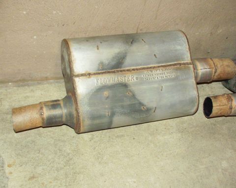 1989 Ford Bronco - Flowmaster muffler with visible patent information and rusted inlet/outlet pipes.