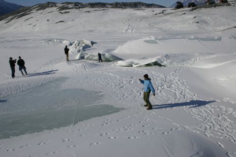 2003 Jeep TJ - Several off-road vehicles are visible on a snow-covered terrain, with a few individuals standing around.