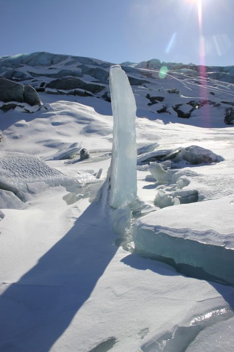 2003 Jeep TJ - A striking ice formation stands tall against a backdrop of a glacier and a bright sun.
