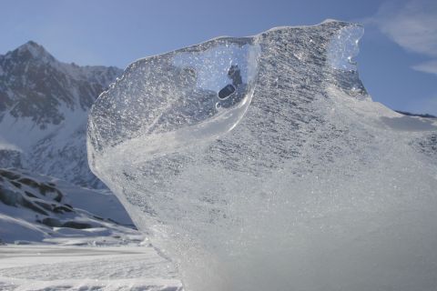 2003 Jeep TJ - A large ice formation stands in a snowy landscape with mountains under a clear blue sky.